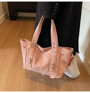 Détails du sac fourre-tout rose pêche avec texture mate et rivets argentés élégants