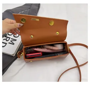 Top view of compact crossbody box bag interior showing capacity for phone and makeup