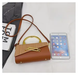 Brown crossbody bag with straw weave detail compared to a tablet for size reference