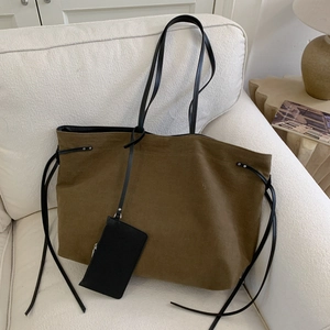 Minimalist olive canvas tote bag with black leather straps and matching small pouch