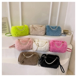 Close-up of plush crossbody bags in eight colors with pearl handles and leather straps