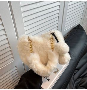 Detailansicht der weißen Plüschtasche mit goldener Metallkette und flauschigen Anhängern