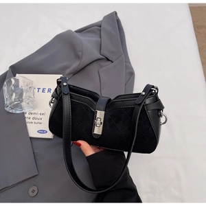 Detailed view of black baguette bag with quilted leather and silver metal twist lock