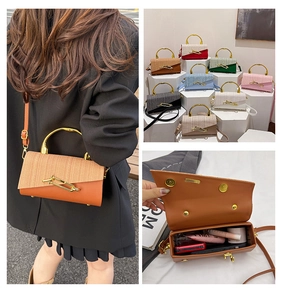 Detail view of stylish color-block crossbody bag featuring golden handles and storage space