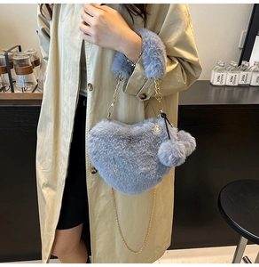 Graue herzförmige Plüschtasche mit goldener Kette und flauschigen Bommel-Anhängern