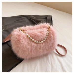 Detailed shot of pink plush faux fur bag featuring white pearl handle and shoulder strap