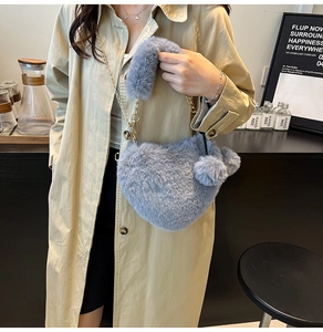 Detailansicht der herzförmigen grauen Plüschtasche mit Goldkette und flauschigen Anhängern
