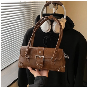 Detailed shot of retro brown oil wax leather shoulder bag with silver buckle and rivets