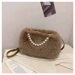 Close-up of brown plush faux fur handbag with elegant pearl handle and zipper closure