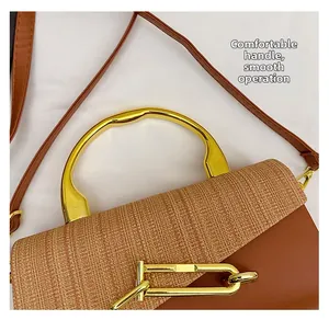 Detail of a brown contrast box bag featuring a woven lid and smooth gold metal handle