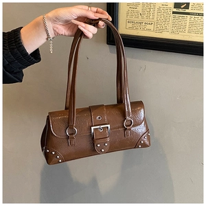 Detailed view of brown patent leather baguette bag with silver studs and metal buckle