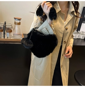 Nahaufnahme der schwarzen Plüsch-Herzhandtasche mit Goldkette an einem Modell
