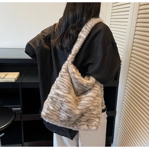 Detail of soft faux fur tote bag with brown animal texture on a model shoulder
