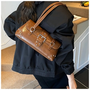 Detail of vintage brown leather underarm bag with silver rivets and metallic buckle strap