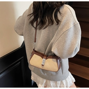Chic beige quilted fabric baguette bag with brown leather accents shown on a model