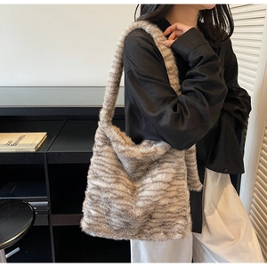Detailed macro of the fluffy faux fur texture and striped pattern on the large hobo tote