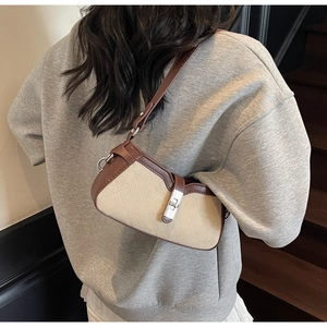 Quilted baguette bag in khaki fabric and brown leather shown on model's shoulder