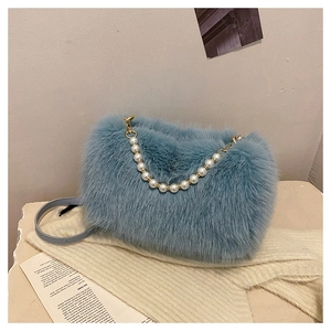 Detail of light blue faux fur handbag with elegant pearl handle and metal hardware