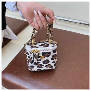 Détail du mini sac boîte léopard avec fermoir camélia doré et bandoulière en chaîne