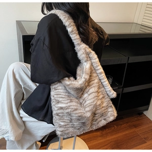 Detail of soft faux fur shoulder bag featuring a grey zebra pattern texture
