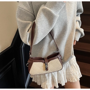 Detail of vintage baguette bag featuring brown leather trim and silver metal buckle lock