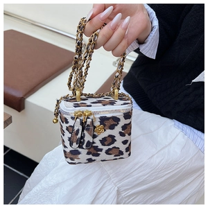 Détail du mini sac boîte à imprimé léopard avec chaîne dorée et breloque fleur