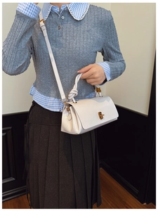 White faux leather shoulder bag with twisted rope handle and gold metallic twist lock