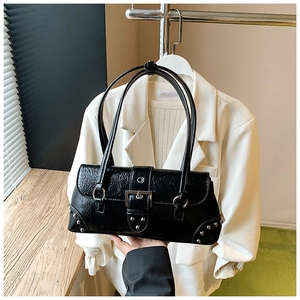 Detail of black pleated leather bag with silver buckle and stud accents on blazer background