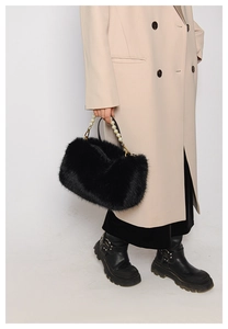 Detail of black faux fur handbag featuring elegant white pearl bead handle for winter