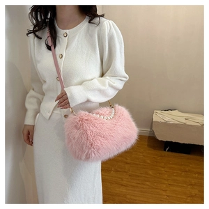Detail of pink faux fur shoulder bag with elegant pearl handle and soft plush texture