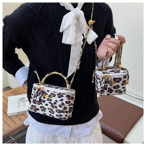 Détail de mini sacs boîte léopard avec logo fleur dorée et bandoulières en chaîne