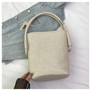 Gros plan détaillé montrant la texture tissée fine et la poignée du sac panier beige