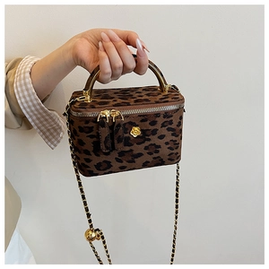 Détail du sac boîte léopard avec poignée en métal doré et bandoulière chaîne à boucle