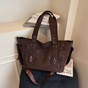 Grand sac cabas marron minimaliste avec clous et bandoulière sur fond vintage