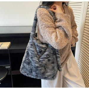 Close-up of a large grey and black striped faux fur tote bag with thick shoulder strap