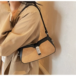 Detail of retro baguette bag with quilted suede texture and silver twist lock buckle