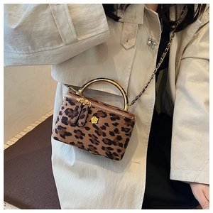Gros plan du mini sac boîte léopard avec poignée dorée et détail de fleur de camélia