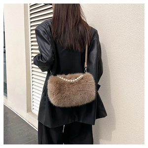Close-up of brown faux fur handbag with elegant pearl accents and thin leather strap