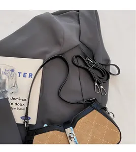 Detail of camel suede baguette bag featuring black leather trim and silver metal twist lock