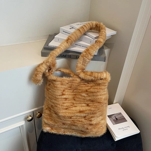 Close-up of plush tiger print tote bag with soft faux fur texture and warm orange tones
