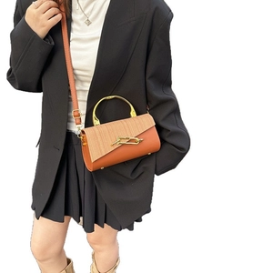 Chic two-tone leather crossbody box bag with metal handle and unique golden lock