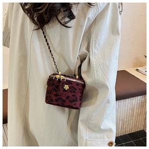 Détail du mini sac boîte à imprimé léopard avec fleur dorée et bandoulière