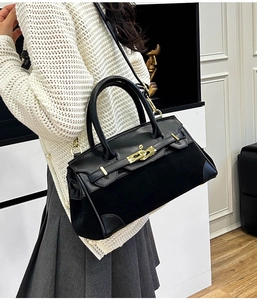 Détail du sac Kelly noir structuré avec panneau mat et fermoir rotatif doré élégant