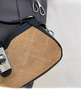 Macro shot of brown quilted suede texture and black leather trim with silver twist lock