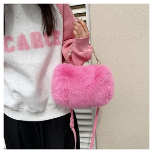 Detailed close-up of pink plush shoulder bag with elegant pearl handle and soft texture