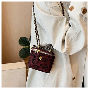 Détail du mini sac vanité léopard en velours avec camélia doré et bandoulière chaîne