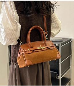 Vue détaillée du sac en cuir marron avec empiècement en daim et fermoir doré