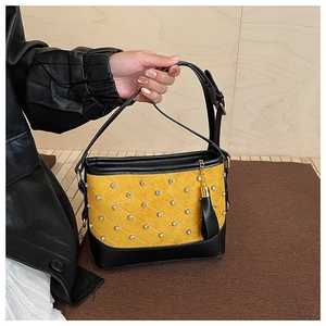 Detail of yellow suede crossbody bag with rhombus stitching and sparkling rhinestones