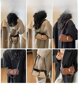 Detail view of contrast stitch baguette bag showing shoulder and crossbody carrying options