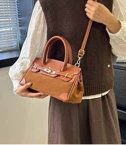 Détail d'un sac à main en cuir mat marron caramel avec fermoir tournant métallique